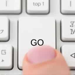 Nahaufnahme einer Tastatur mit Finger, der die GO-Taste drückt.